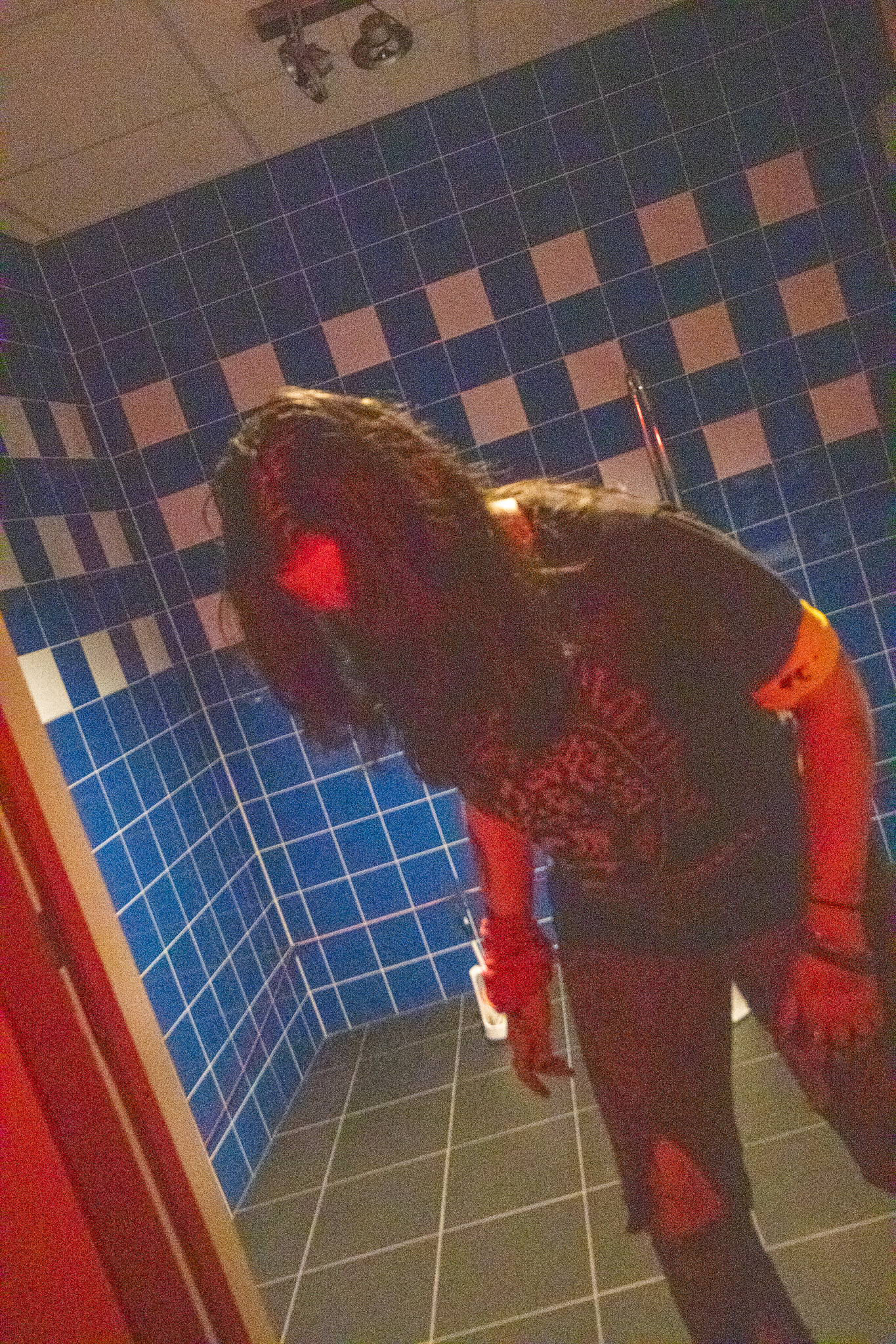 Zombie lurking in dark corridor with red lighting